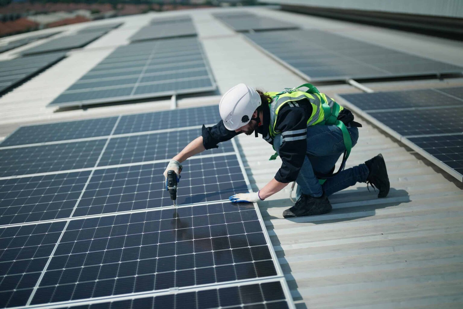 Técnico a instalar painéis fotovoltaicos numa cobertura empresarial — imagem ilustrativa